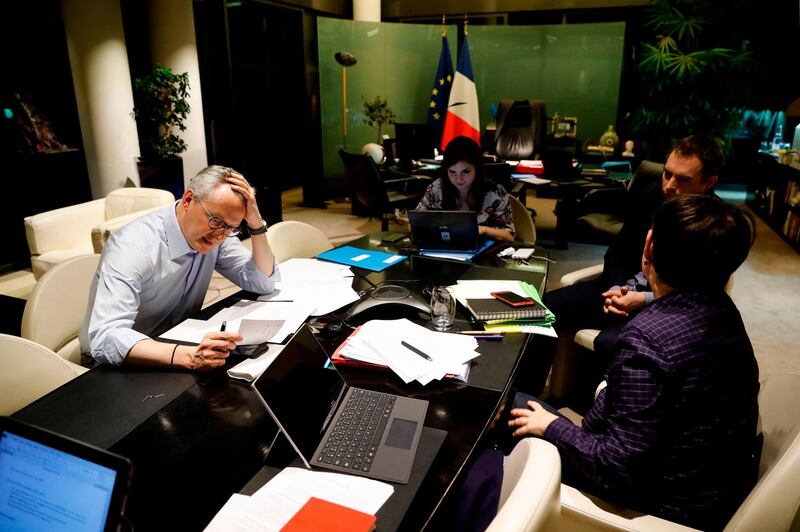 French Economy and Finance Minister Bruno Le Maire (L) speaks on the phone with his German counterpart as his advisor Juliette Oury (C), his cabinet director Emmanuel Moulin (2nd R) and French Treasury director Odile Renaud-Basso attend, during a break in a videoconference meeting of the Eurogroup of eurozone finance ministers to discuss coronavirus response on April 7, 2020 at the French Economy ministry in Paris. EU finance ministers hope to agree a coronavirus economic rescue package for the worst-hit member states on Tuesday, but will fall short of demands from beleaguered Spain and Italy. / AFP / Thomas SAMSON
