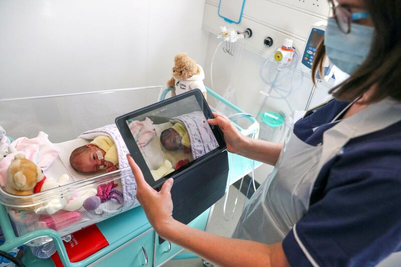 FRIMLEY, ENGLAND - MAY 22: Image released on May 27, A nurse makes a video of a newborn baby in the maternity ward at Frimley Park Hospital in Surrey to send to the parents as visiting hours are restricted because of COVID pandemic on May 22, 2020 in Frimley, United Kingdom. The hospital is part of the Frimley Health NHS Foundation Trust which has said that with Covid-19 pressure gradually reducing, they are planning to increase the number of procedures it provides, with more outpatient, diagnostic, endoscopy and surgical services and priority given to the most urgent work, for example, cancer diagnoses and treatments. (Photo by Steve Parsons - Pool/Getty Images)