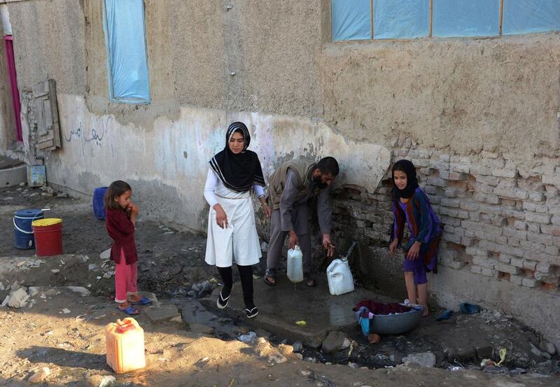 Aziza Rahimzada collects drinking water with slum residents at a refugee camp in Kabul.