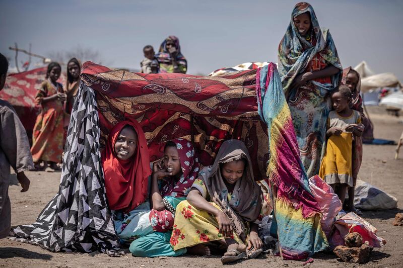 Sudanese girls gather under a make-shift shade at the transit centre for refugees in Renk