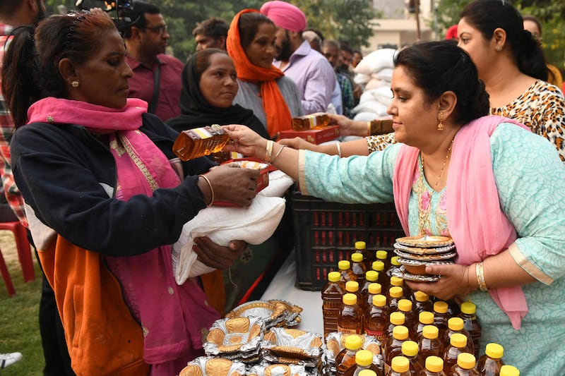 Members of the Just Sewa Society distribute lamps and grocery items to people in need during an event ahead of Diwali, in Amritsar. AFP