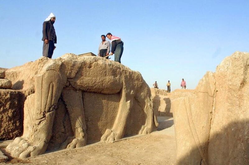 A file picture taken on July 17,  2001 shows Iraqi workers cleaning a statue of winged bull at an archeological site in Nimrud, 35 Kilometers southeast of the northern city of Mosul. ISIL has begun bulldozing the ancient Assyrian city of Nimrud in Iraq, the government said. Karim Sahib / AFP Photo

