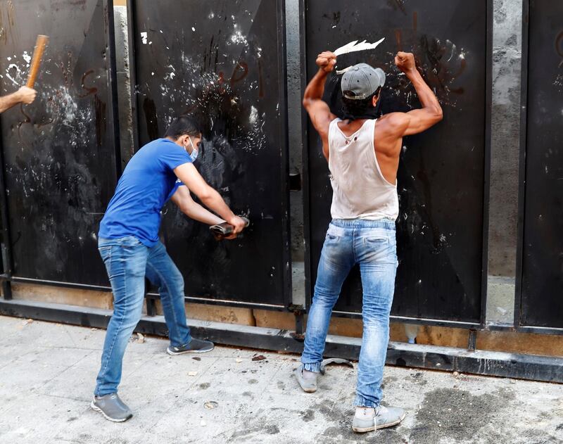 Demonstrators try to break a fence during a protest following Tuesday's blast in Beirut's port area. Reuters