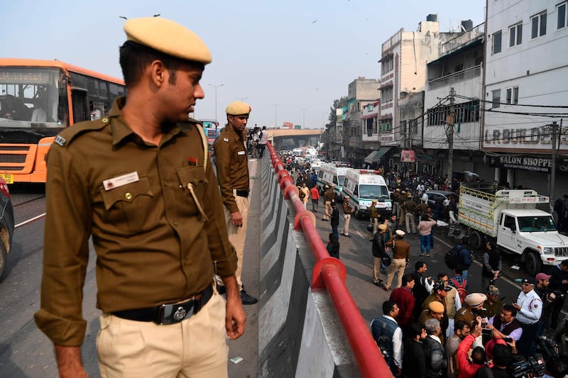 Police personnel stand guard along a flyoner road to prevent onlookers from gathering following a factory fire in Anaj Mandi area of New Delhi. At least 43 people have died in a factory fire in India's capital New Delhi.  AFP