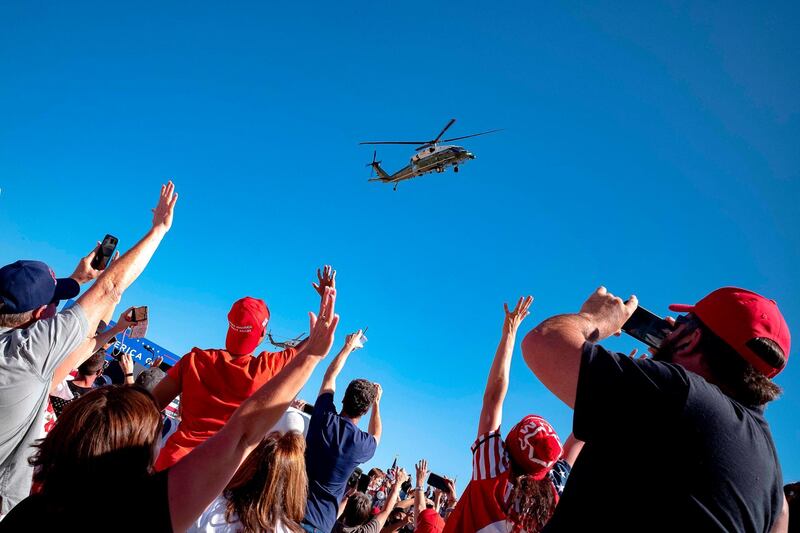 Supporters wave as Marine One with US President Donald Trump aboard takes off after a rally at Prescott Regional Airport in Prescott, Arizona.  AFP