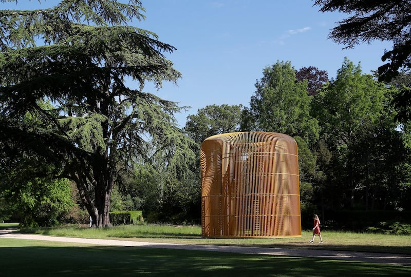 Hannah Vitos of the Blenheim Art Foundation, poses for a photograph next to artist Ai Weiwei's Gilded Cage (2017) sculpture in the grounds of Blenheim Palace in Woodstock, Britain, June 2, 2021.  REUTERS/Peter Nicholls