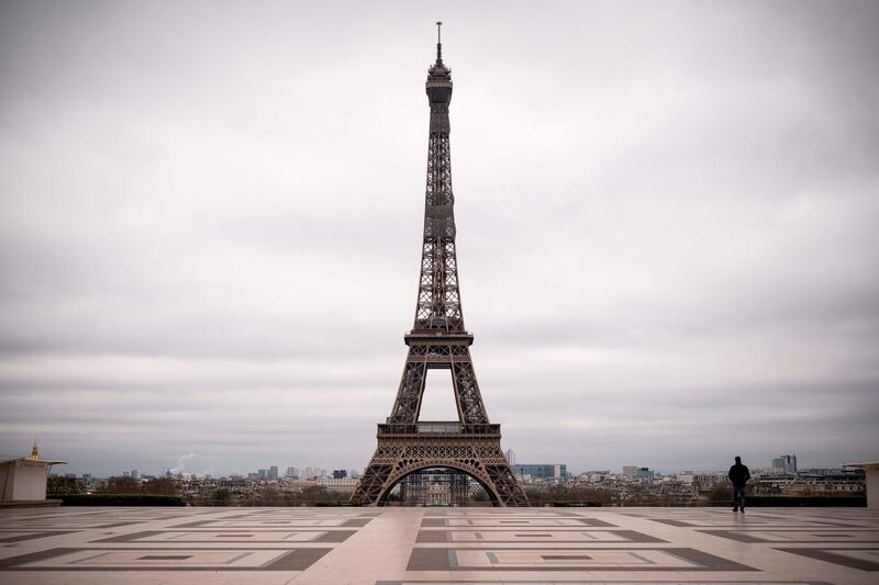 A man walks on the deserted Trocadero square in front of the Eiffel Tower in Paris on the fifth day of a strict nationwide lockdown. AFP