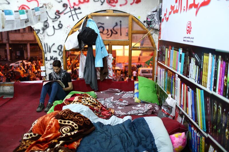 An Iraqi demonstrator reads a newspaper at a makeshift library in an abandoned Turkish building during the ongoing anti-government protests in Baghdad. Reuters