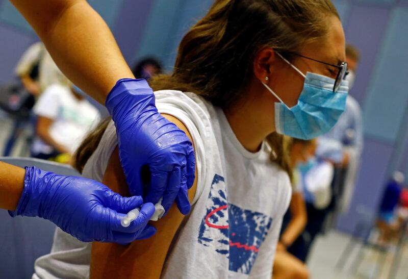 A nurse administers the first dose of the Moderna vaccine to Tatiana Suarez, 15, in Spain on July 28, 2021. Reuters