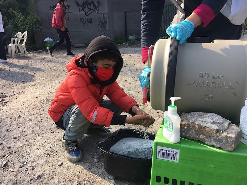 A child migrant gets water at one of the camps of Calais and Dunkirk, northern France. Care4Calais