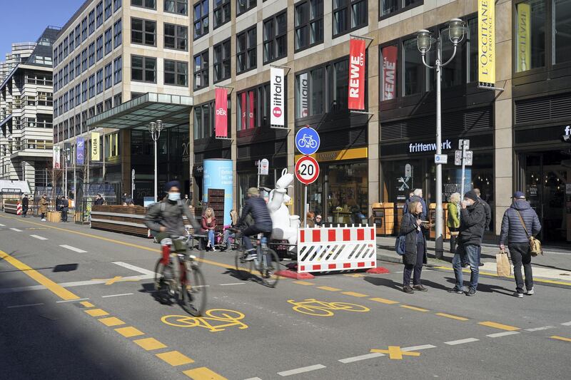 BERLIN, GERMANY - MARCH 22: People linger outside at midday on Friedrichstrasse shopping street, which has been turned into a bicycle street free of cars, during the third wave of the coronavirus pandemic on March 22, 2021 in Berlin, Germany. German Chancellor Angela Merkel and leaders of Germany's 16 states are convening today over lockdown measures going forward. According to initial media reports the leaders have agreed to continue the current lockdown well into April in an effort to stem the spread of the B117 variant. Germany has seen a substantial and continuous rise in new infections of COVID-19 since the end of February.  (Photo by Sean Gallup/Getty Images)