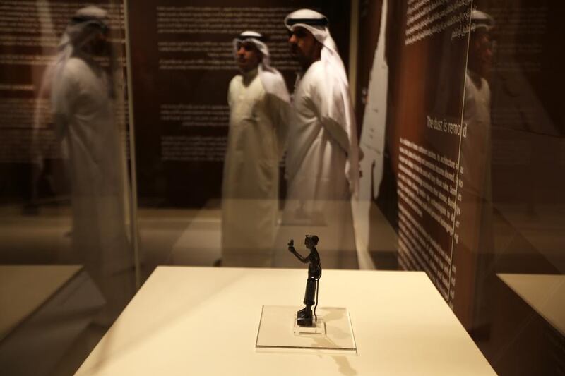 A bronze statuette of a man holding a bird, from the ancient site of Mleiah in Sharjah and on show at the Archaeology Museum. Pawan Singh / The National