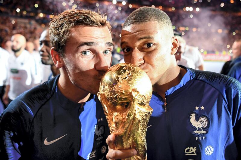 France's forward Antoine Griezmann (L) and France's midfielder Kylian Mbappe (R) kiss the 2018 World Cup trophy as they celebrate during a ceremony for the victory of the 2018 World Cup at the end of the UEFA Nations League football match between France and Netherlands at the Stade de France stadium, in Saint-Denis, northern of Paris, on September 9, 2018. / AFP PHOTO / FRANCK FIFE