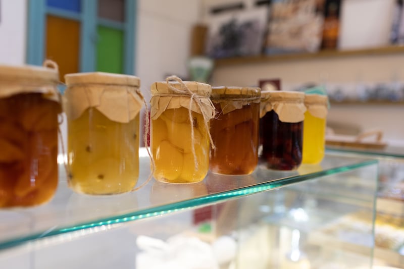 Jars of fruit preserves, made by women in Syria, sit on a glass counter at Levant Book Cafe.