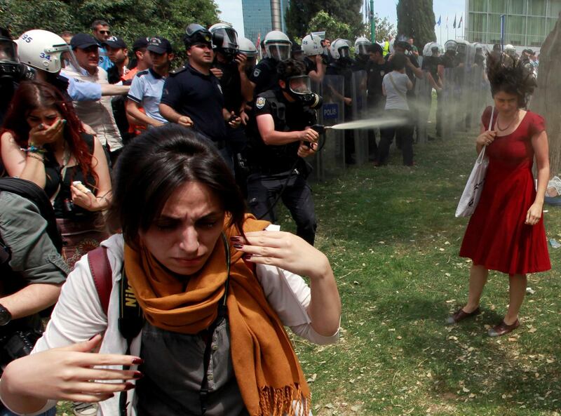 A Turkish riot policeman uses tear gas as people protest against the destruction of trees in a park brought about by a pedestrian project, in Taksim Square, Istanbul, May 28, 2013. Picture taken May 28, 2013. REUTERS/Osman Orsal/File Photo   SEARCH "POY DECADE" FOR THIS STORY. SEARCH "REUTERS POY" FOR ALL BEST OF 2019 PACKAGES. TPX IMAGES OF THE DAY.