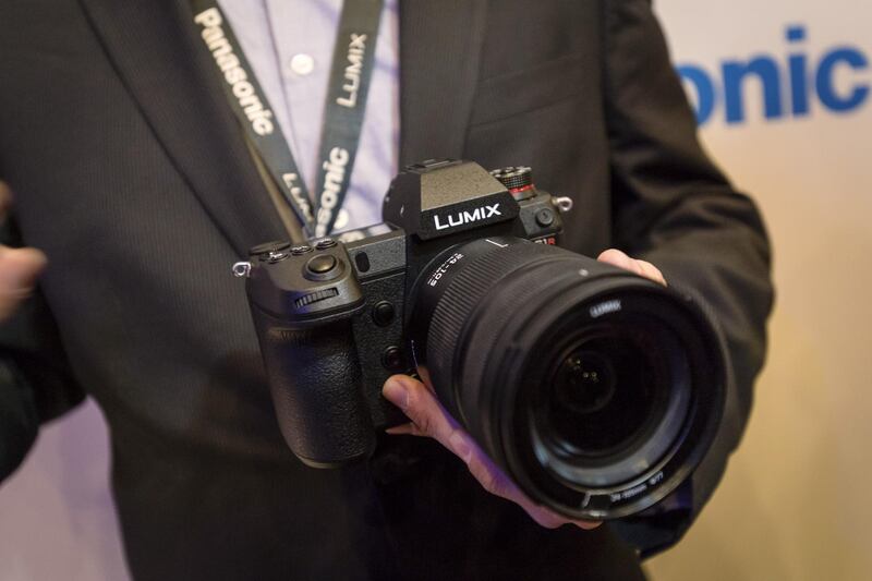 An exhibitor holds a Panasonic Lumix S1R camera. Bloomberg