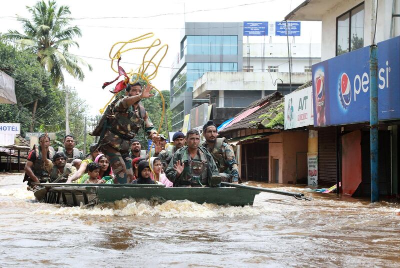 Indian army personal evacuate local residents in a residential area at Aluva in Ernakulam district, in the Indian state of Kerala, on August 17, 2018. - Troop reinforcements stepped up desperate rescue attempts in India's flood-stricken Kerala state on August 17 after more than 100 bodies were found in a day and a half, taking the crisis death toll to at least 164. (Photo by - / AFP)