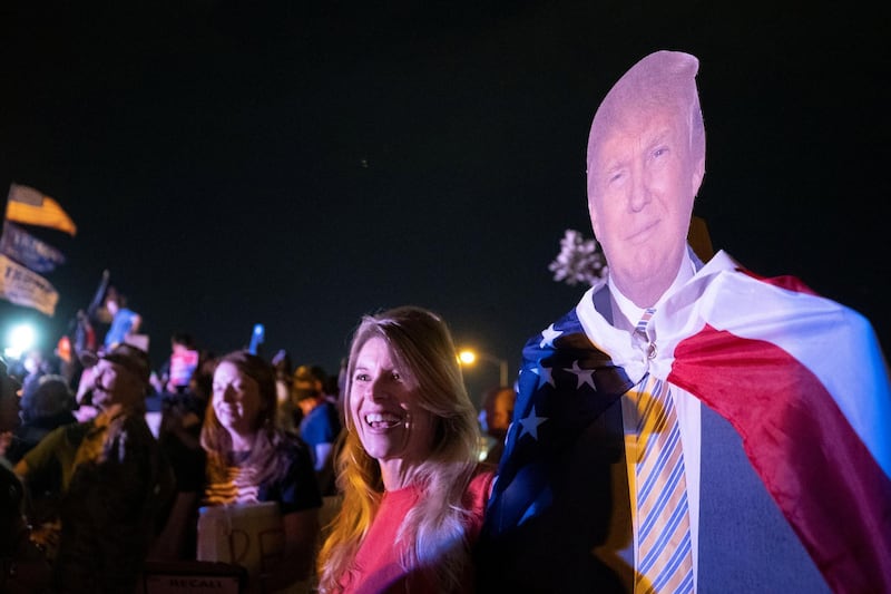 Anne VanHoose holds a cardboard cutout of Donald Trump during a protest. Reuters