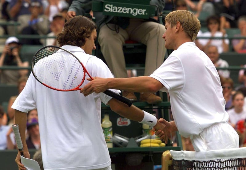 WIM40 - 20000627 - WIMBLEDON, UNITED KINGDOM : Switzerland's Roger Federer (L) gets a clap from Russia's Yevgeny Kafelnikov (R) after their Men's Singles 1st round match at the Wimbledon 2000 tennis tournament on Tuesday, 27 June 2000. Kafelnikov in a thrilling match finally won 7-5, 7-5 and 7-6. (ELECTRONIC IMAGE) 
EPA PHOTO EPA/YURI KADOBNOV/mb/kr