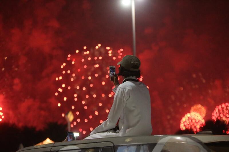 People watch the fireworks along the corniche in Abu Dhabi Monday evening. Fatima Al-Marzouqi / The National