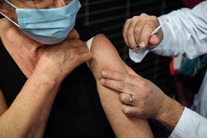 An elderly woman receives a dose of the Pfizer-BioNtech Covid-19 vaccine at a vaccination centre in Garlan, western France. AFP