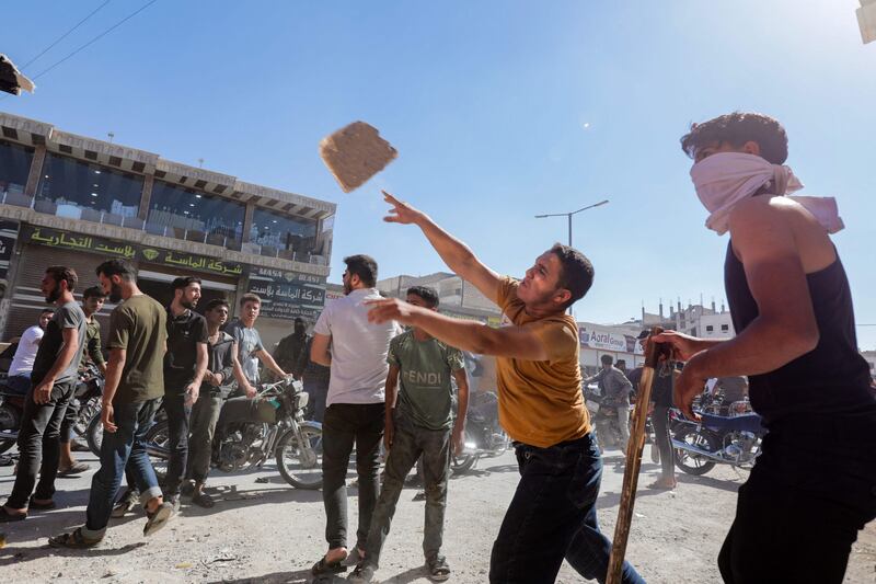 A protester throws a rock at a Turkish lorry in Al Bab. AFP