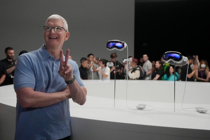 Apple chief executive Tim Cook with the company's Vision Pro headsets. AP