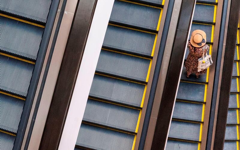 A visitor rides an escalator at a shopping mall in downtown Bangkok.  AFP