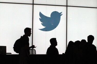 Employees walk past a lighted Twitter logo as they leave the company's headquarters in San Francisco. AFP