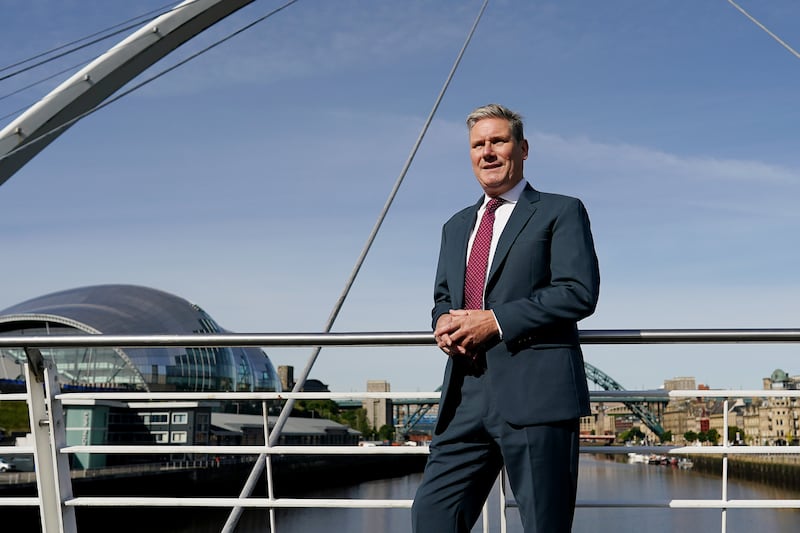 Mr Starmer poses in a navy suit in Newcastle in 2022
