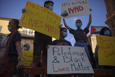 Protesters hold signs during a demonstration against the Israeli police after border police officers shot and killed Iyad al-Halak, an unarmed autistic Palestinian man, in the mixed Arab Jewish city of Jaffa, near Tel Aviv, Israel, after saying they suspected he was carrying a weapon, Sunday, May 31, 2020. AP