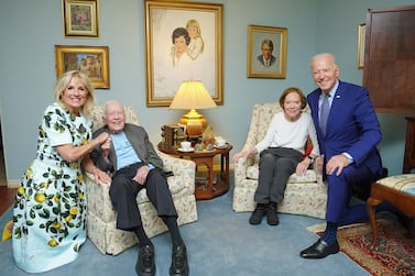 This oddly shot photo showing the Bidens looming over the Carters has gone viral. AP