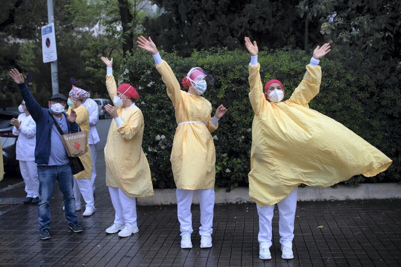 -- AFP PICTURES OF THE YEAR 2020 --

Heathcare workers wearing face masks and protective suits acknowledge applause outside the Hospital de Barcelona on April 13, 2020 in Barcelona, during a national lockdown to prevent the spread of the COVID-19 disease. - Spain reopened parts of its coronavirus-stricken economy on Monday as slowing death tolls in some of the worst-hit countries boosted hopes the outbreak may be peaking and lockdowns could soon be eased. (Photo by Josep LAGO / AFP)