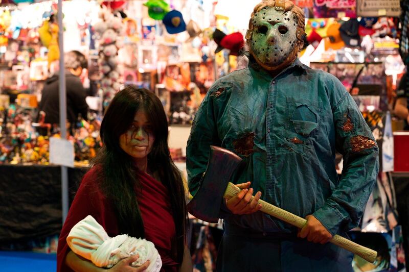 A man dressed as Jason Voorhees from the "Friday the 13th" films stands next to a woman in cosplay. AP Photo