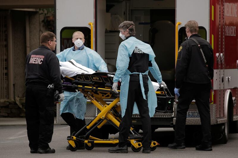 US medics prepare to transfer a patient on a stretcher to an ambulance at the Life Care Center of Kirkland, the long-term care facility linked to the two of three confirmed coronavirus cases in Washington state. Reuters