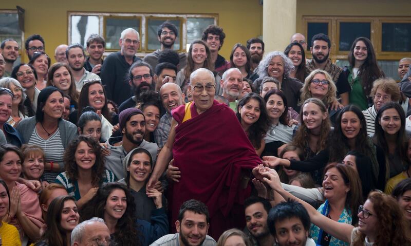 Tibetan spiritual leader the Dalai Lama poses for a group photo with tourists at the Tsuglakhang temple in Dharmsala, India. Ashwini Bhatia / AP Photo