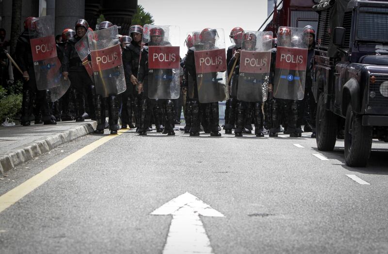 Police stand guard during a protest for the Malaysian opposition leader Anwar Ibrahim outside the Palace of Justice in Putrajaya. Joshua Paul / AP Photo