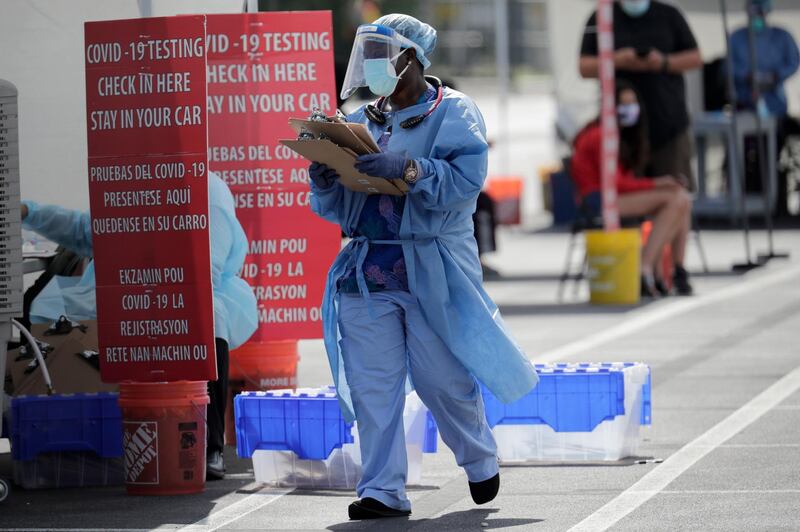 A health care worker works at a COVID-19 testing site sponsored by Community Heath of South Florida at the Martin Luther King, Jr. Clinica Campesina Health Center, during the coronavirus pandemic, Monday, July 6, 2020, in Homestead, Fla. (AP Photo/Lynne Sladky)