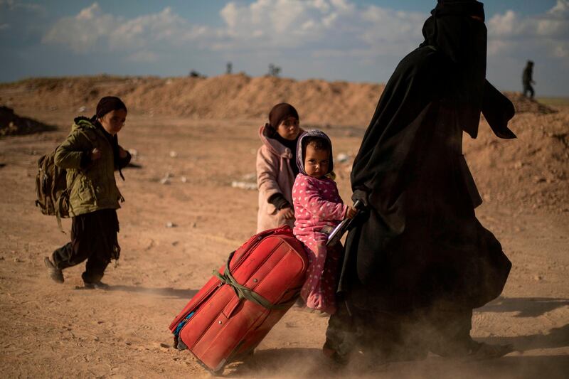A woman evacuated, with her children, from the Islamic State (IS) group's embattled holdout of Baghouz arrives at a screening area held by the US-backed Kurdish-led Syrian Democratic Forces (SDF), in the eastern Syrian province of Deir Ezzor. Veiled women carrying babies and wounded men on crutches hobbled out of the last jihadist village in eastern Syria on March 6 after US-backed forces pummelled the besieged enclave. The Syrian Democratic Forces leading the assault expected more fighters to surrender with their families in tow before moving deeper in the Islamic State group's last redoubt. AFP
