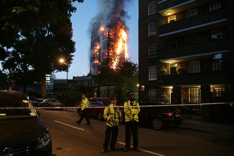 Police control a security cordon as a huge fire engulfs the Grenfell Tower in west London.  Daniel Leal-Olivas / AFP Photo / June 14, 2017