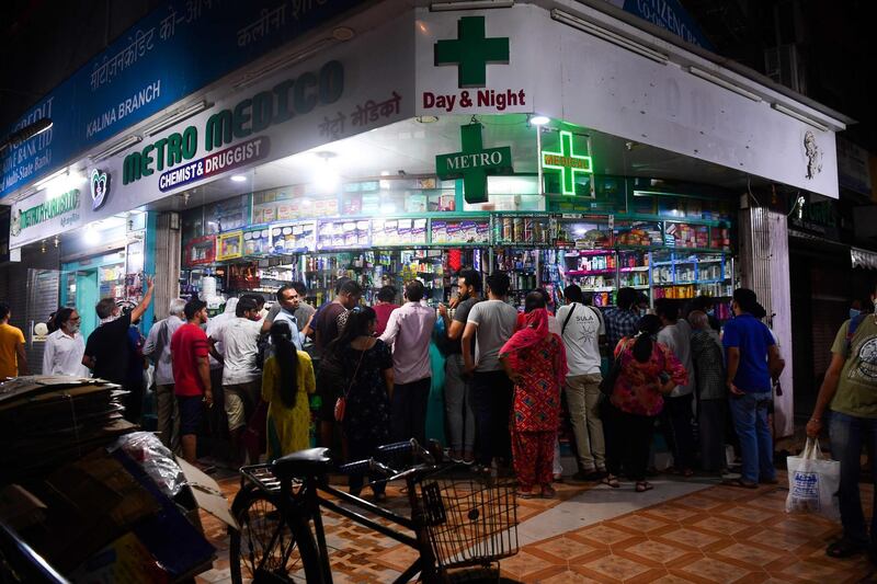 People gather at a pharmacy to buy supplies following Indian Prime Minister's announcement of a government-imposed nationwide lockdown, in Mumbai.  AFP