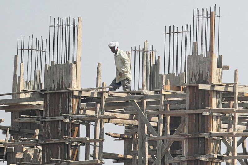 A construction worker walks across the top of a partially completed structure in Cairo, Egypt. Reuters