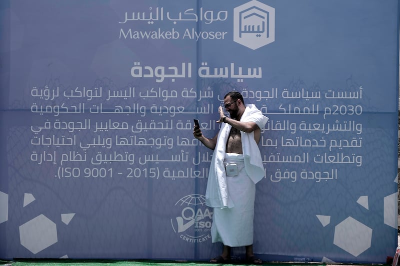 A pilgrim has a video call with his family at the tent camp, in Makkah. AP 
