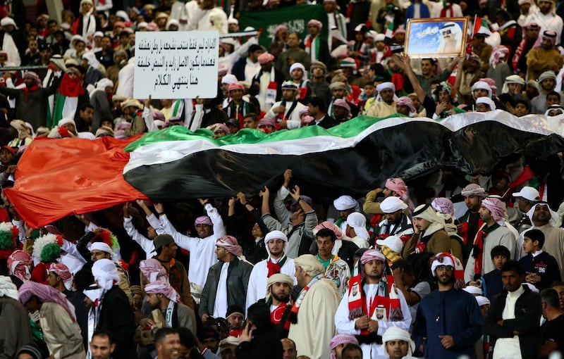 Supporters of the United Arab Emirates (UAE)' national football team wave a giant flag prior the start of the Gulf Cup's final football match between UAE and Iraq on January 18, 2013 in Manama . AFP PHOTO/MARWAN NAAMANI
 *** Local Caption ***  288813-01-08.jpg
