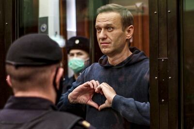 Alexei Navalny makes a heart symbol to his wife Yulia Navalnaya, at a Moscow City Court hearing in 2021. AP 