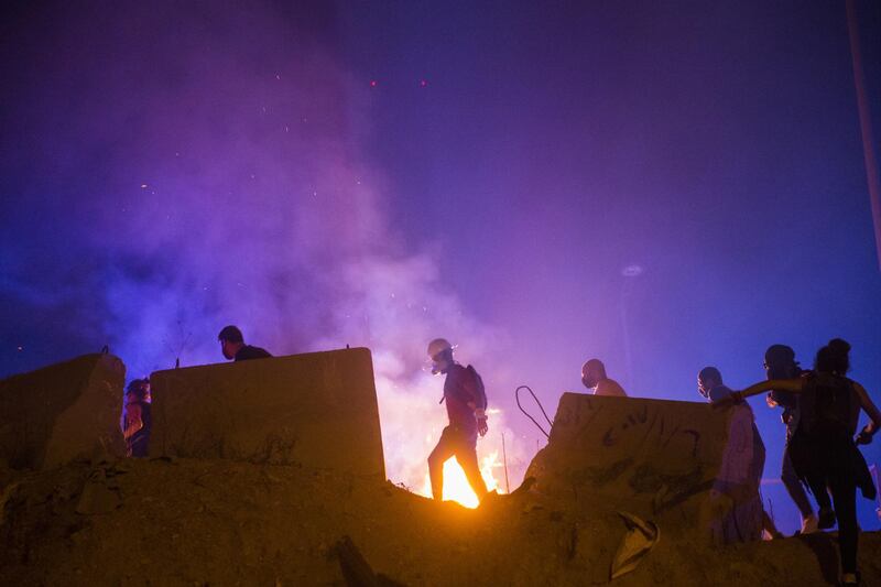 Protesters make their way past a fire lit by an Internal Security Forces tear gas canister during a protest near Martyrs Square in Beirut, Lebanon. Getty Images