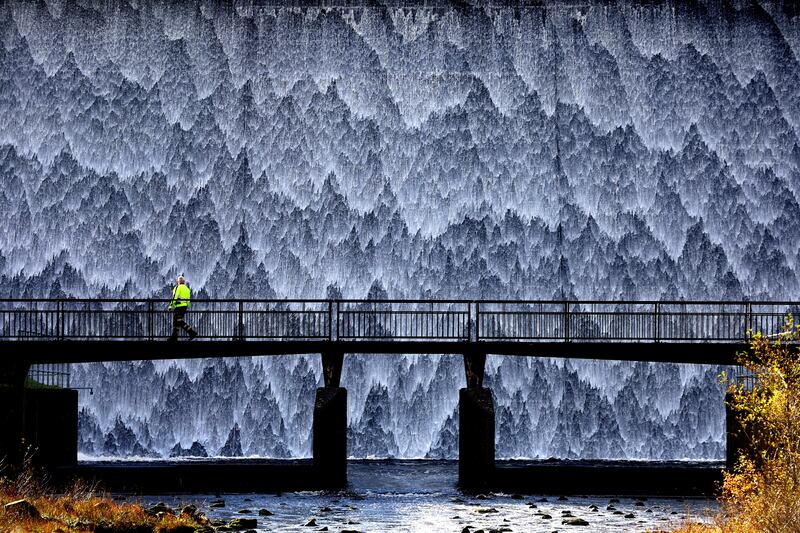 A maintenance worker crosses the bridge at Wet Sleddale Reservoir in Penrith, Cumbria, England, on November 3, 2023. Reuters