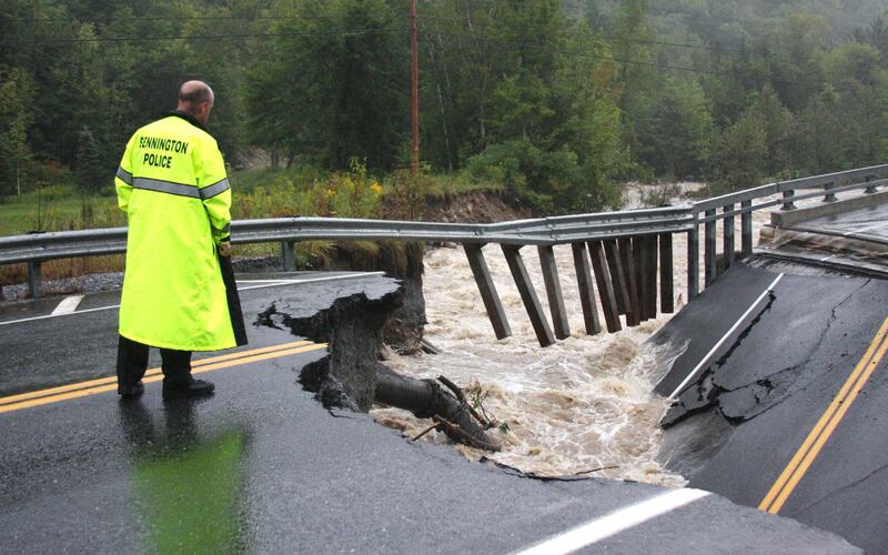 Bennington Police Chief Paul Doucette looks at a collapsed bridge on Route 9 in Woodford, Vt. on Sunday, Aug. 28, 2011. The remnants of Hurricane Irene dumped torrential rains on Vermont on Sunday, flooding rivers and closing roads from Massachusetts to the Canadian border, putting parts of two towns underwater and leaving one young woman swept away and feared drowned in the Deerfield River. (AP Photo/Bennington Banner, Austen Danforth) *** Local Caption ***  Irene.JPEG-08718.jpg