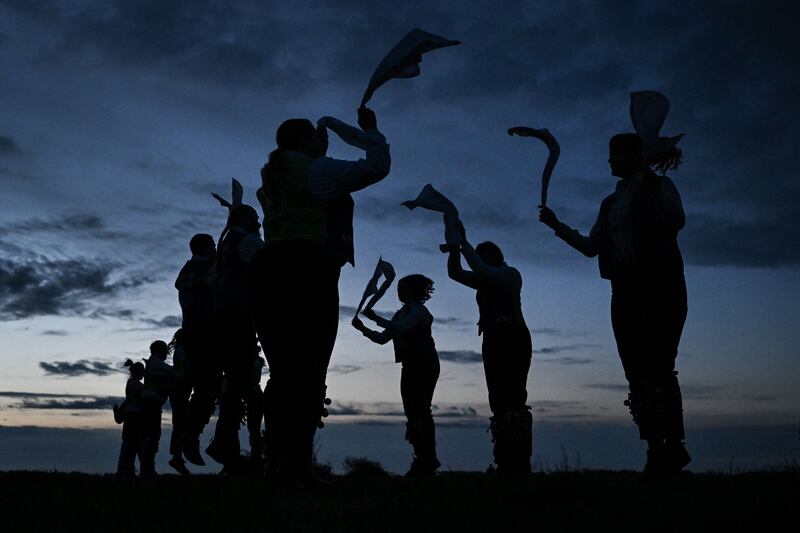 Miserden Morris dancers perform at sunrise on Rodborough Common, in Stroud, western England, as part of the May Day celebrations. AFP