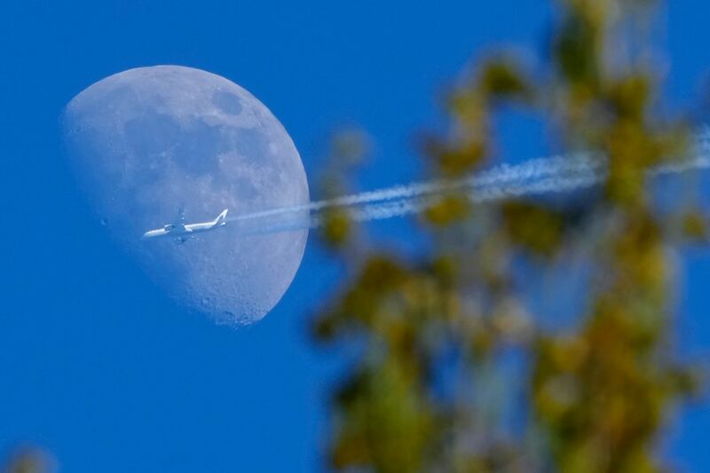 A Boeing 787-9 Dreamliner jet belonging to Air China passes the moon over the village of Podolye, 70km east of St Petersburg, Russia. AP